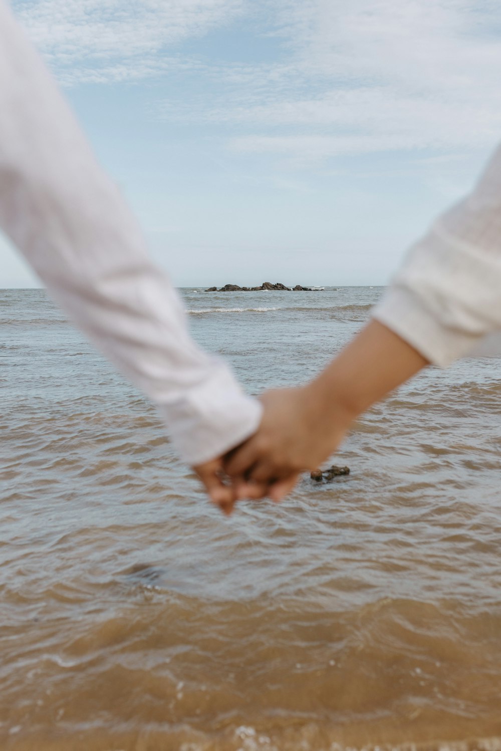 a person holding the hand of another person in the water