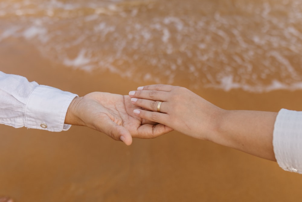 a close up of two people holding hands