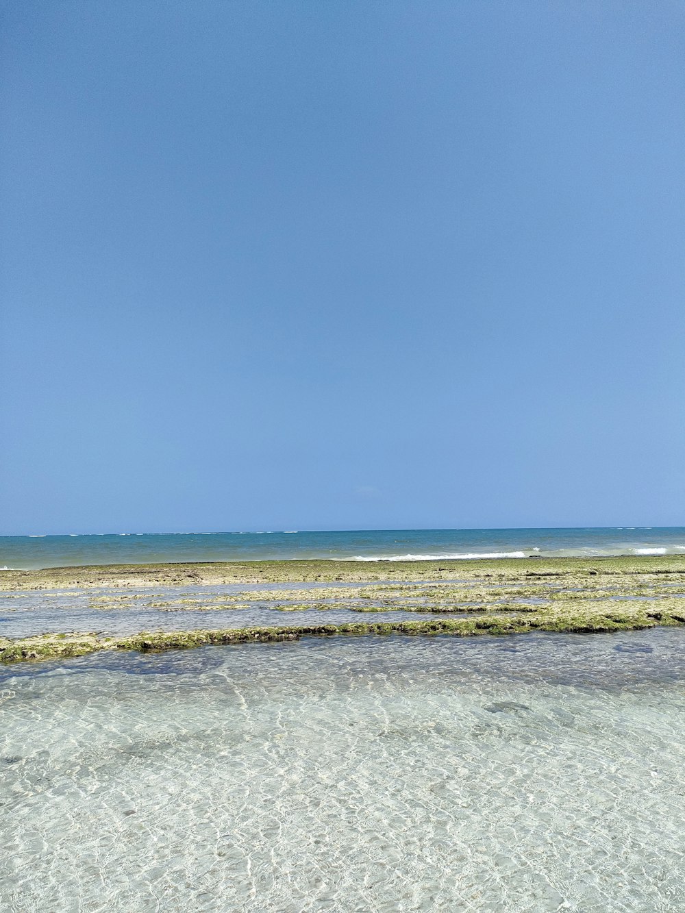 a man riding a surfboard on top of a sandy beach