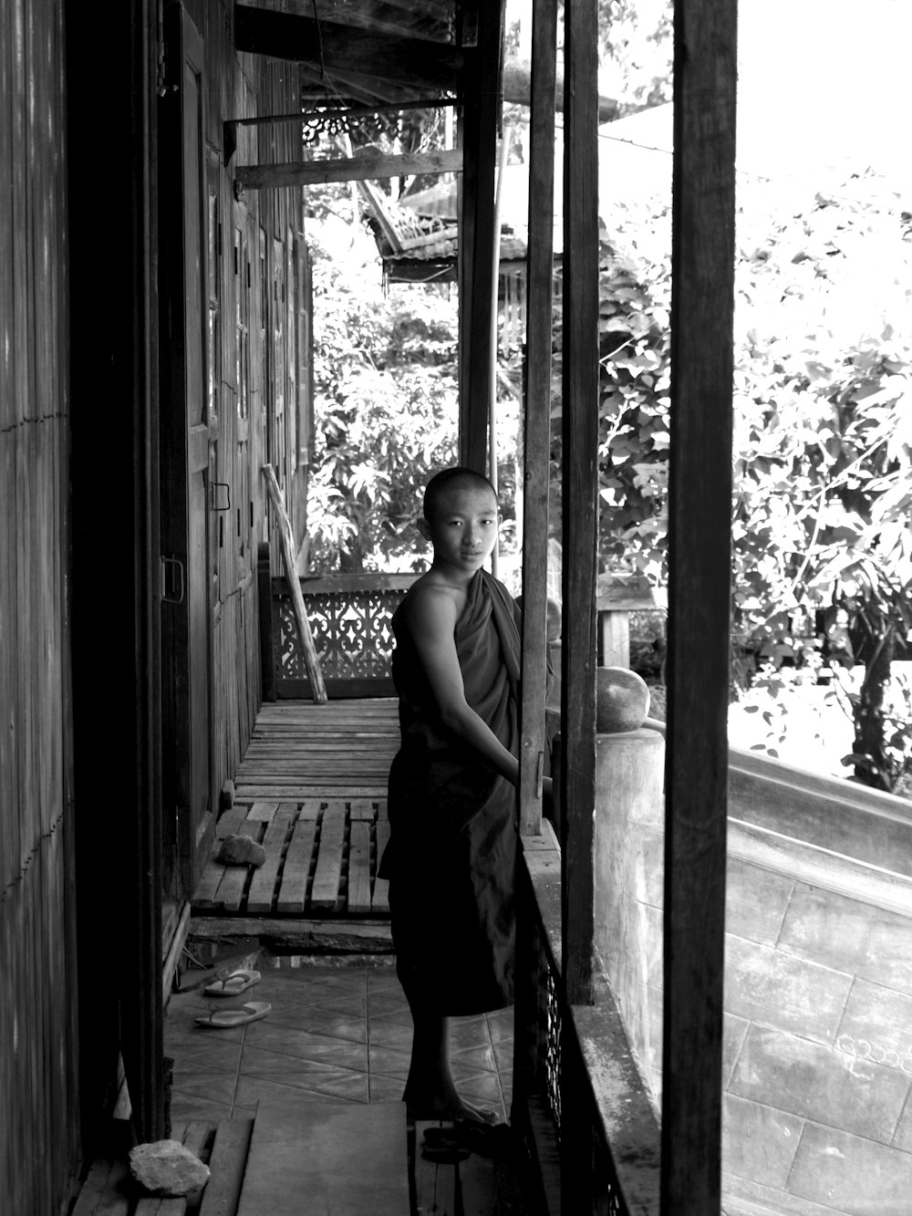 a young boy is standing on a porch