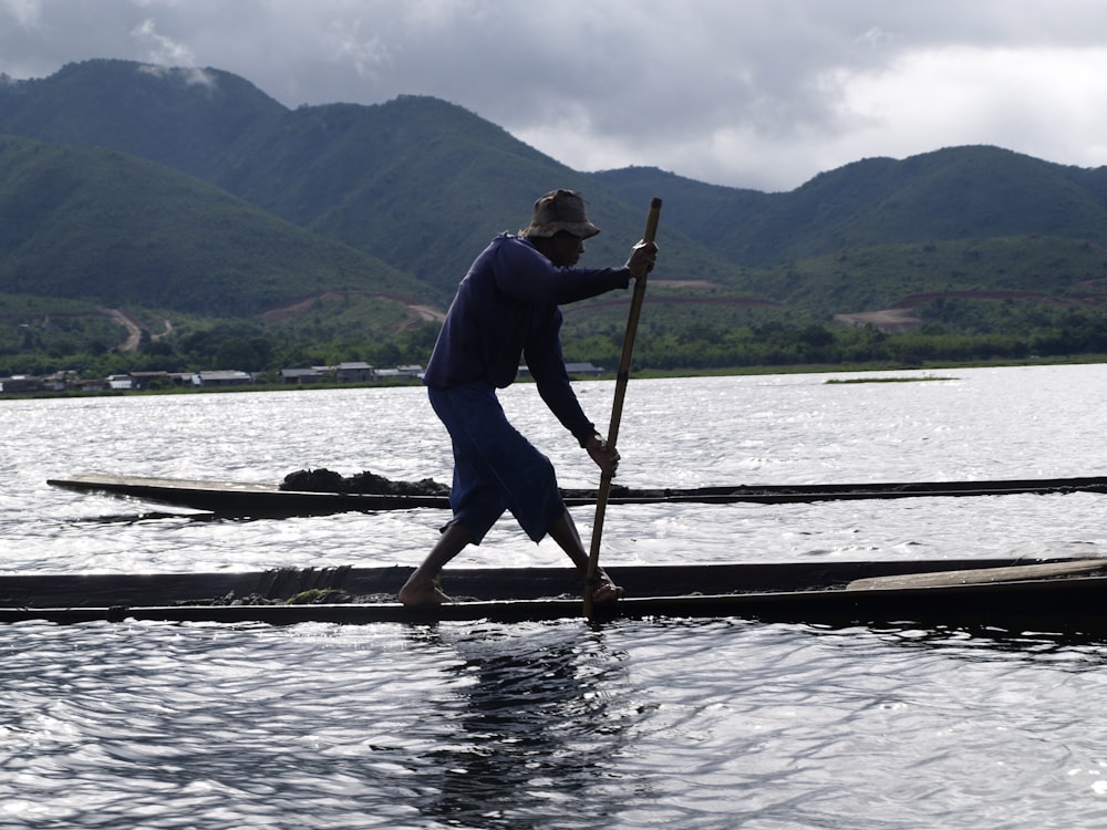 a man standing on top of a boat in the water