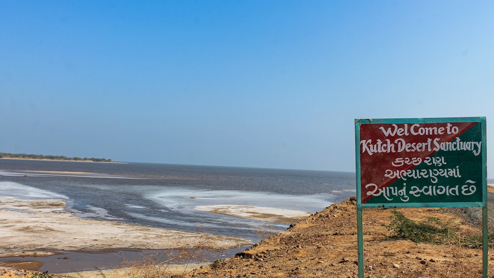 a welcome sign on the side of a beach