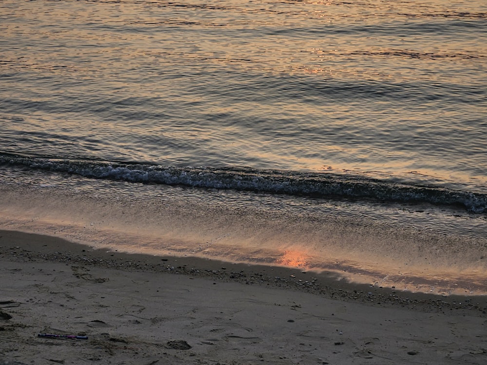 a person walking on the beach with a surfboard