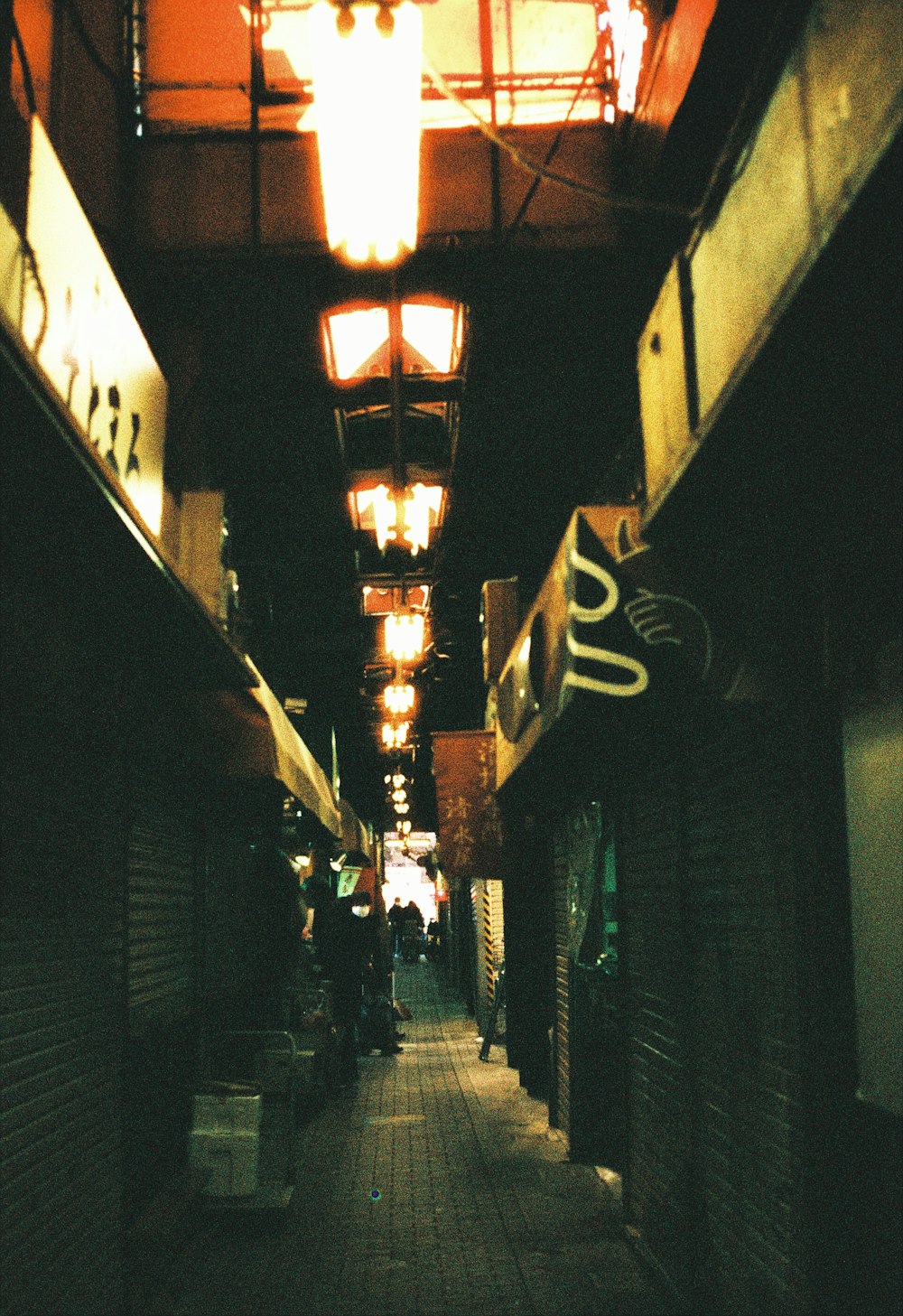 a narrow alley way with people walking down it