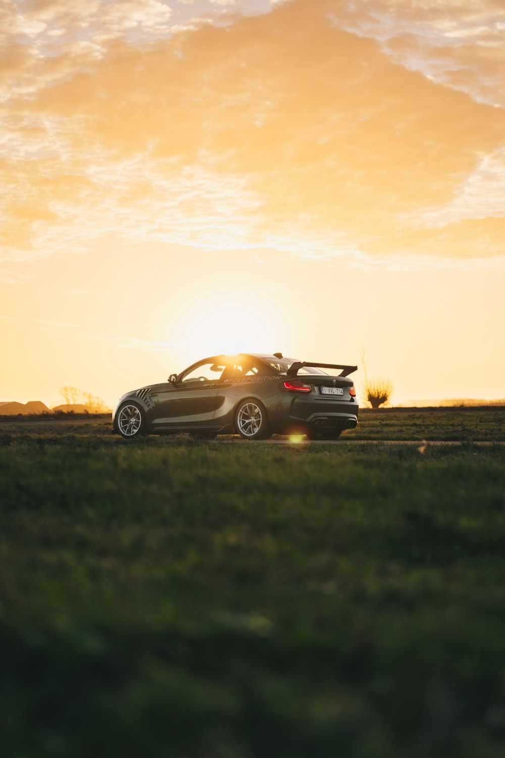 a car parked in a field at sunset