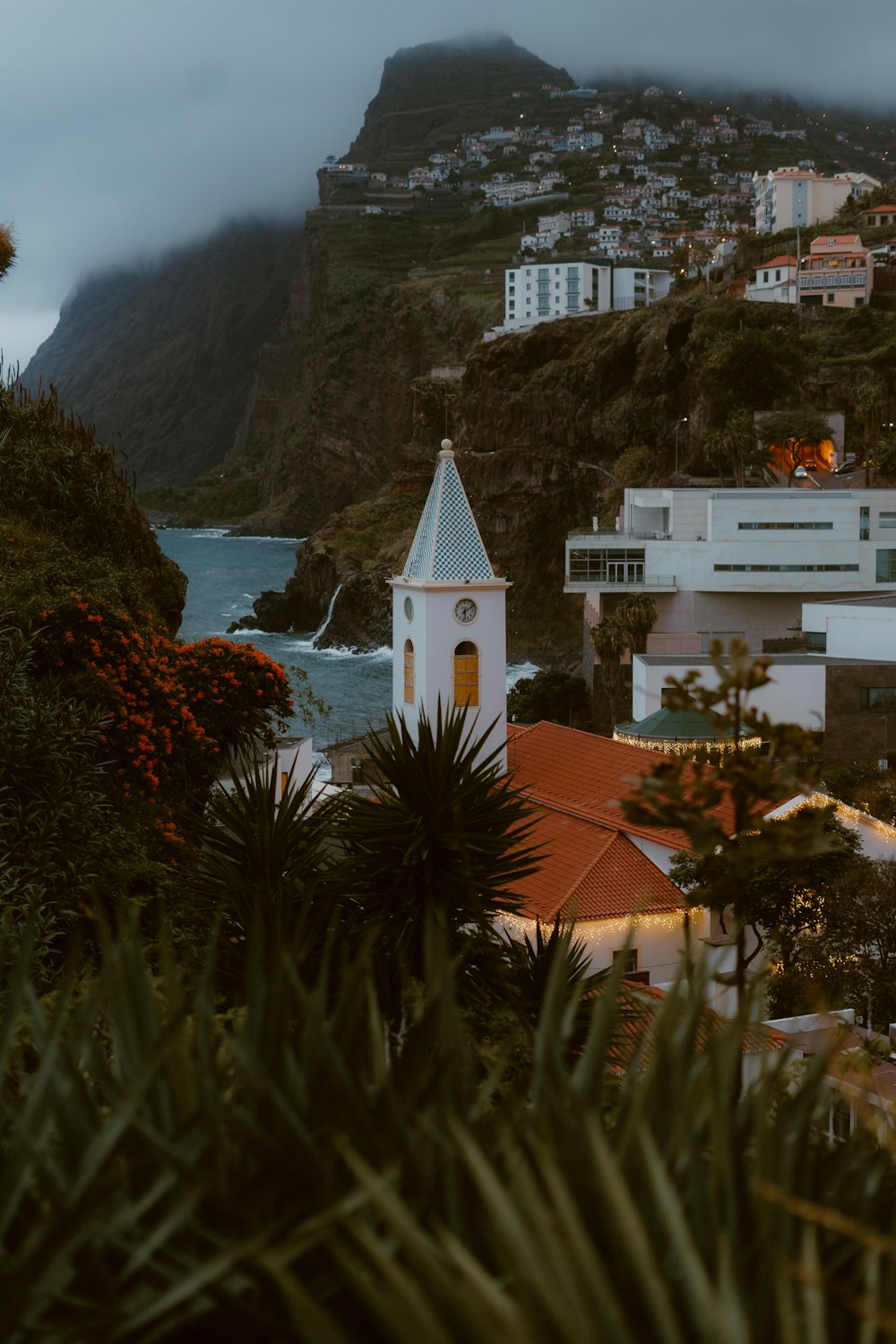 a view of a town with a steeple and a body of water