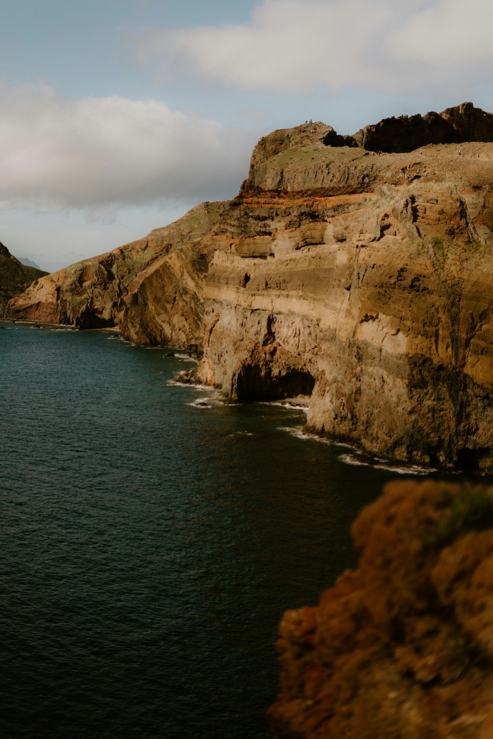 a large body of water near a rocky cliff