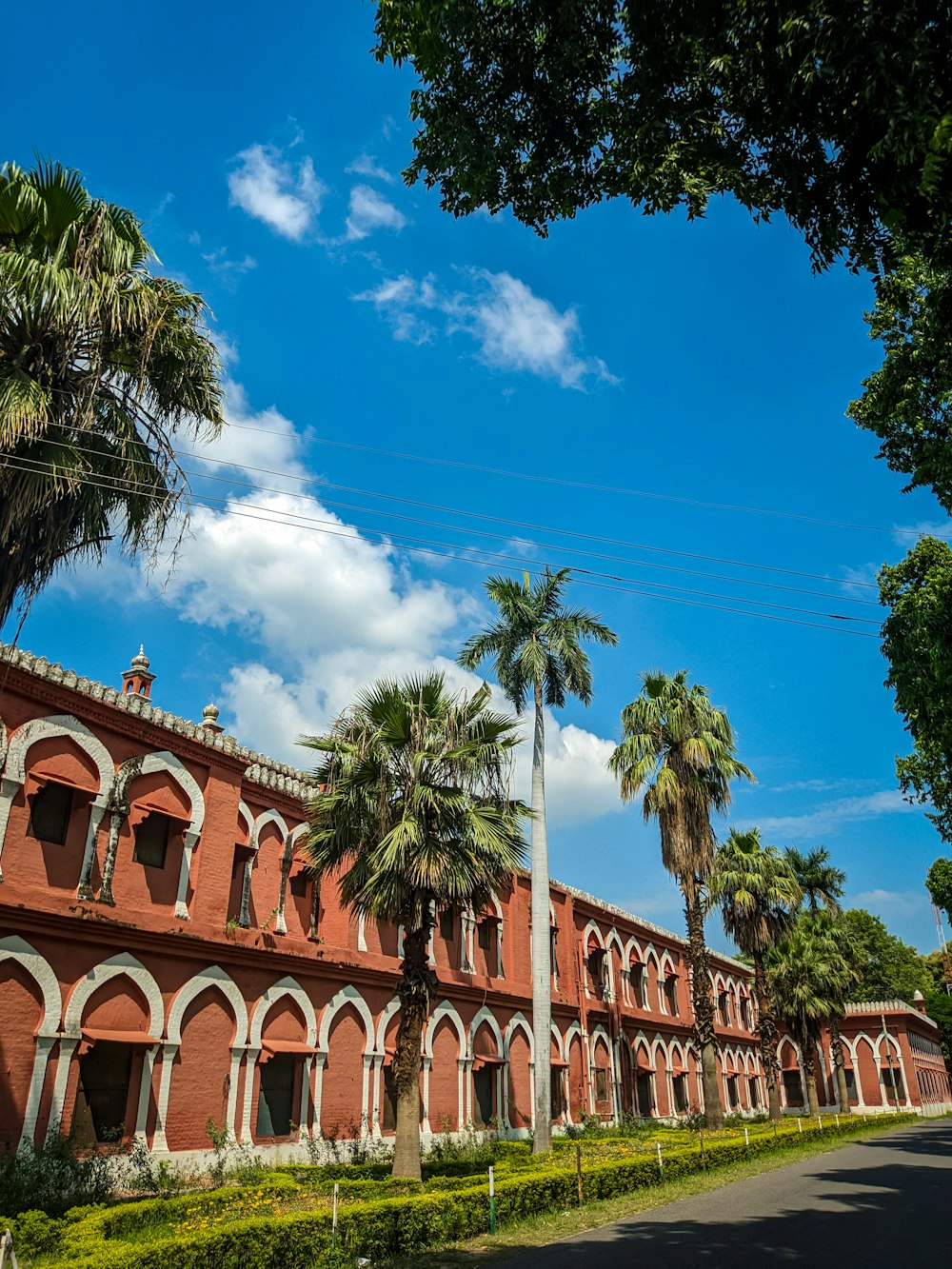 a red brick building surrounded by palm trees