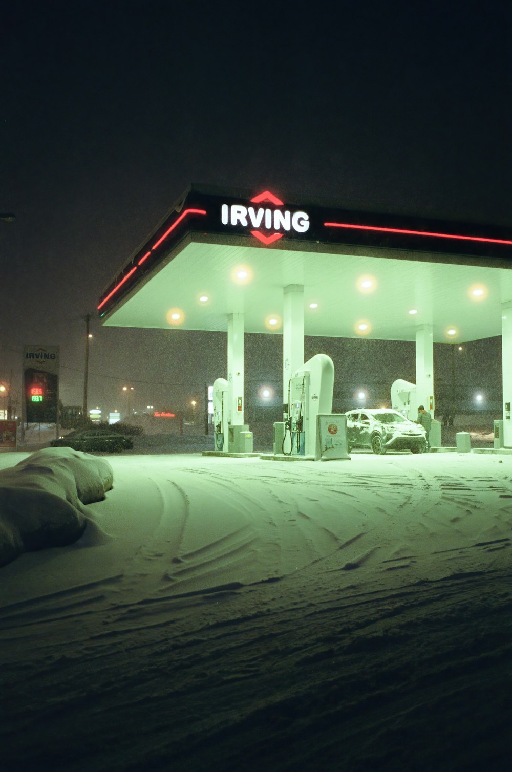 a gas station at night with snow on the ground