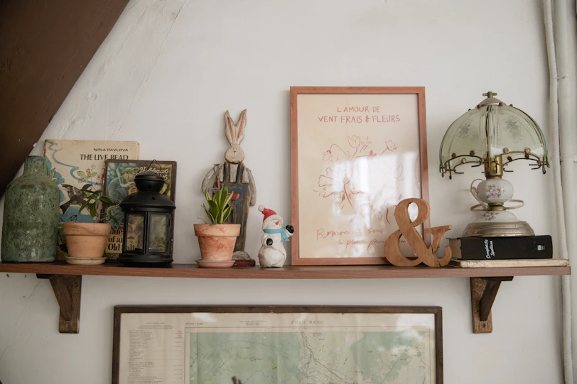 a shelf that has some books and a lamp on it