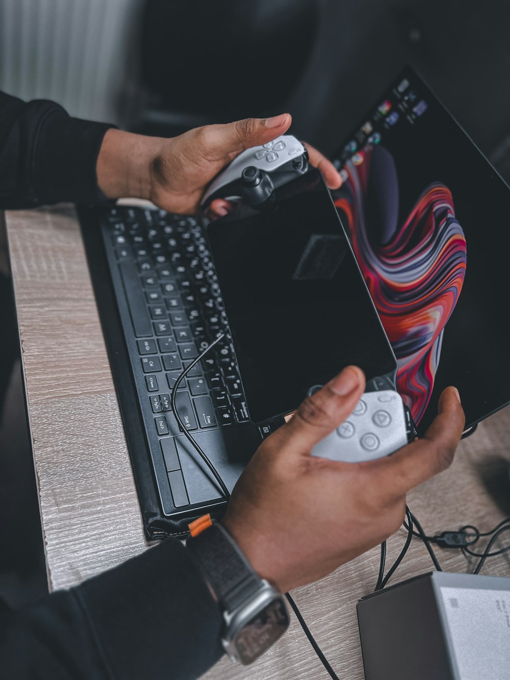 a person holding a remote in front of a laptop