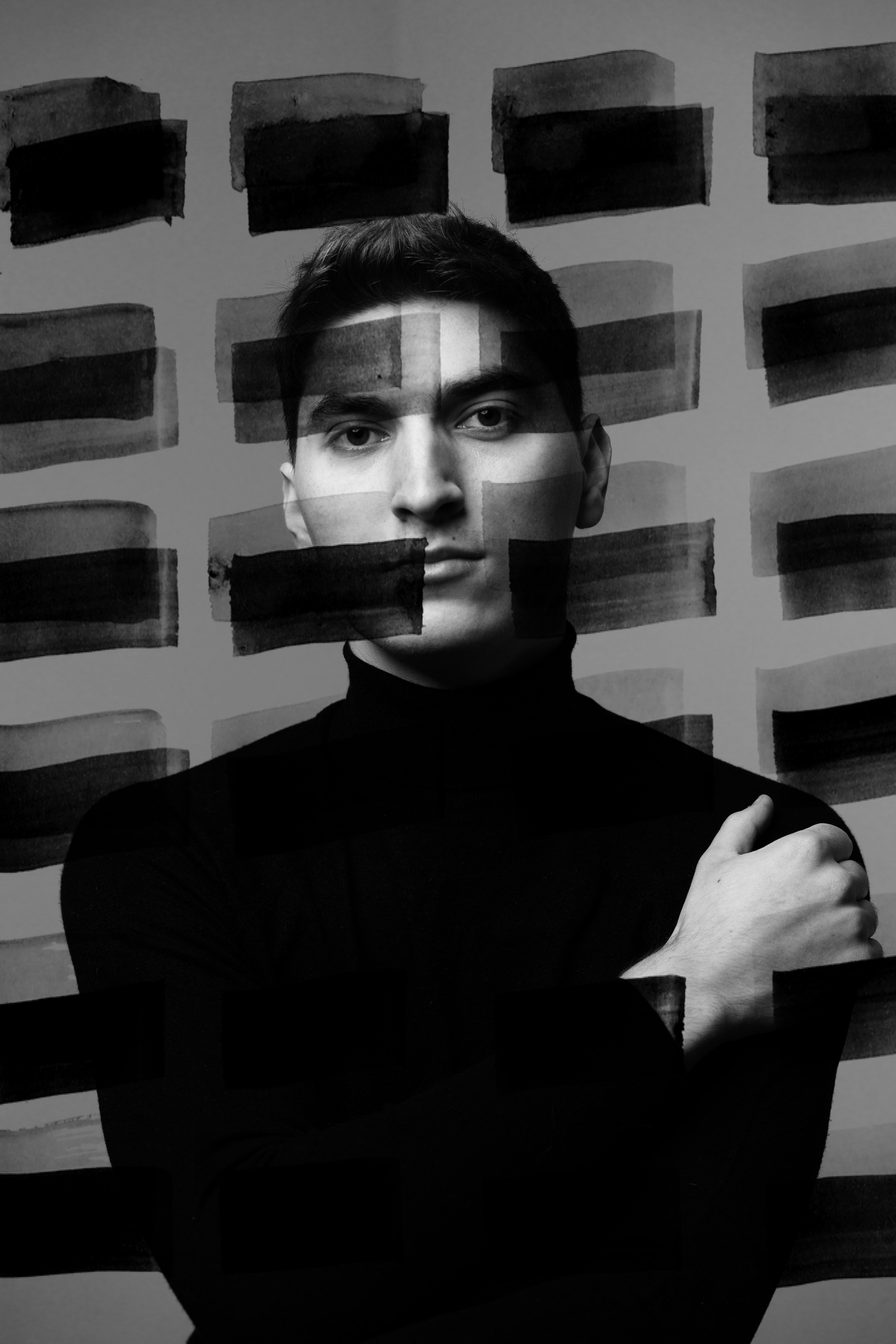 un homme debout devant un mur couvert de carrés