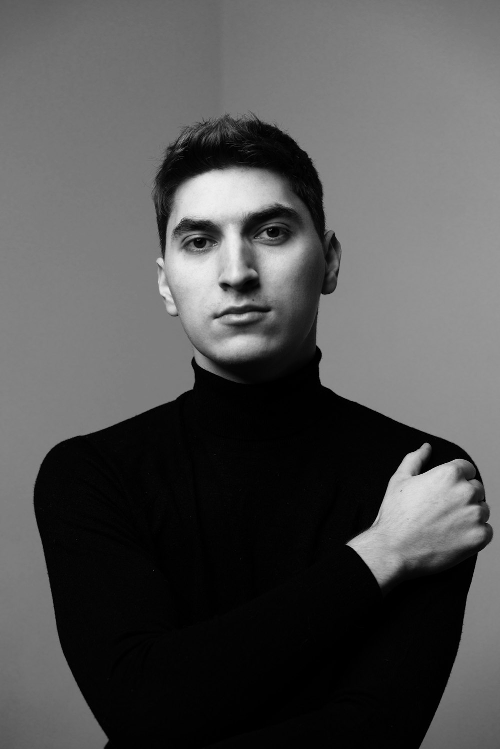 a black and white photo of a man with his arms crossed