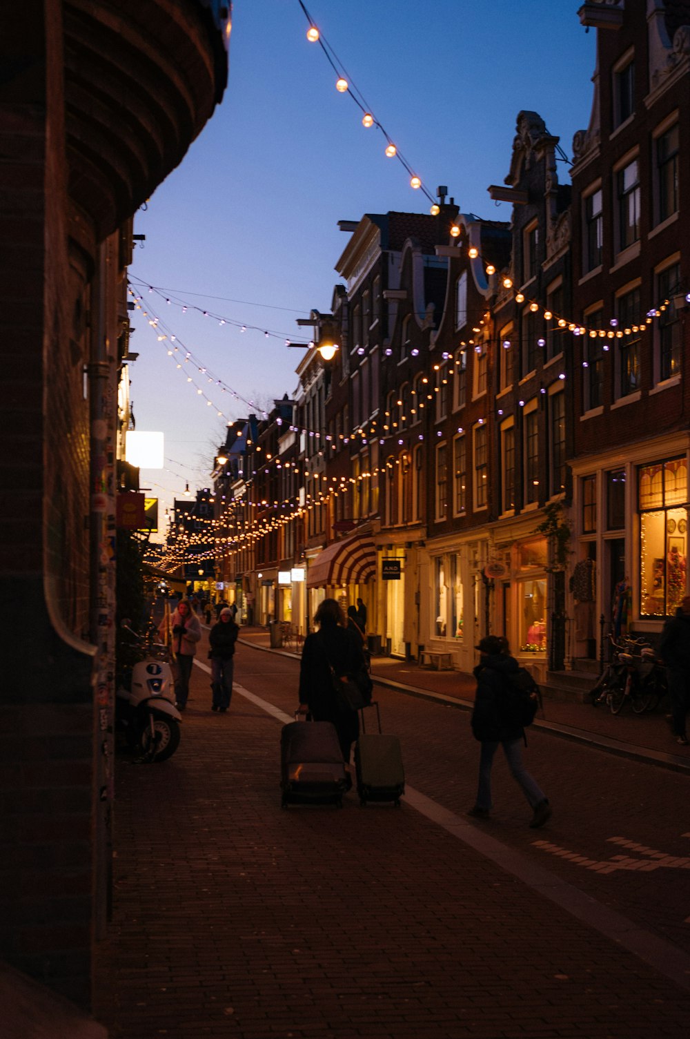 people walking down a city street at night