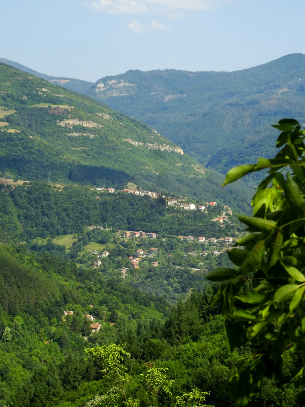 a view of a lush green valley surrounded by mountains