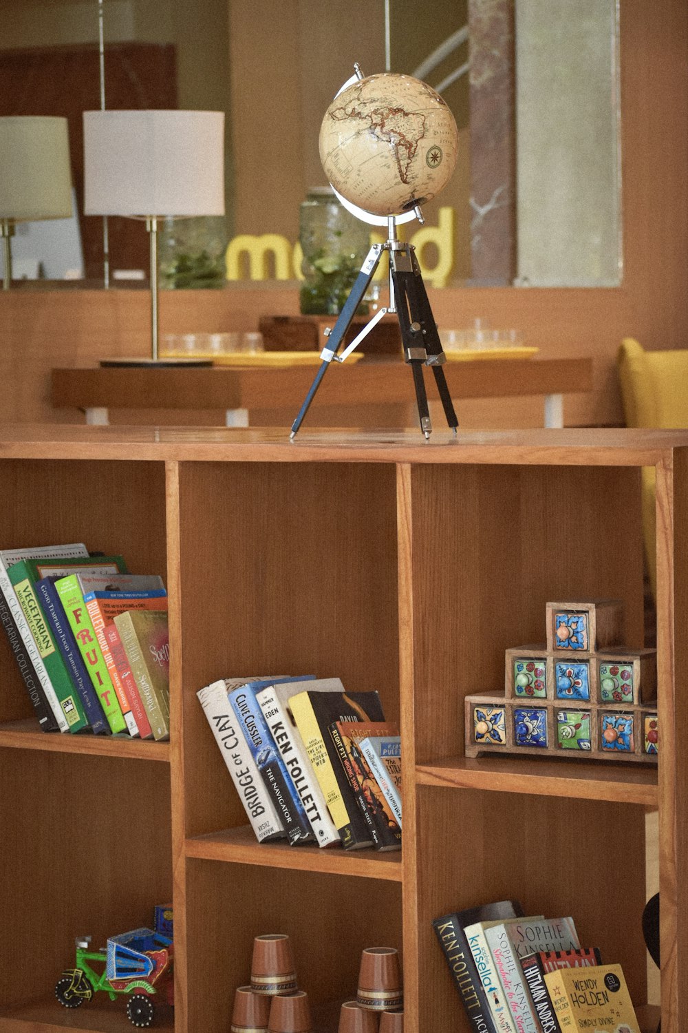 a bookshelf with a globe on top of it