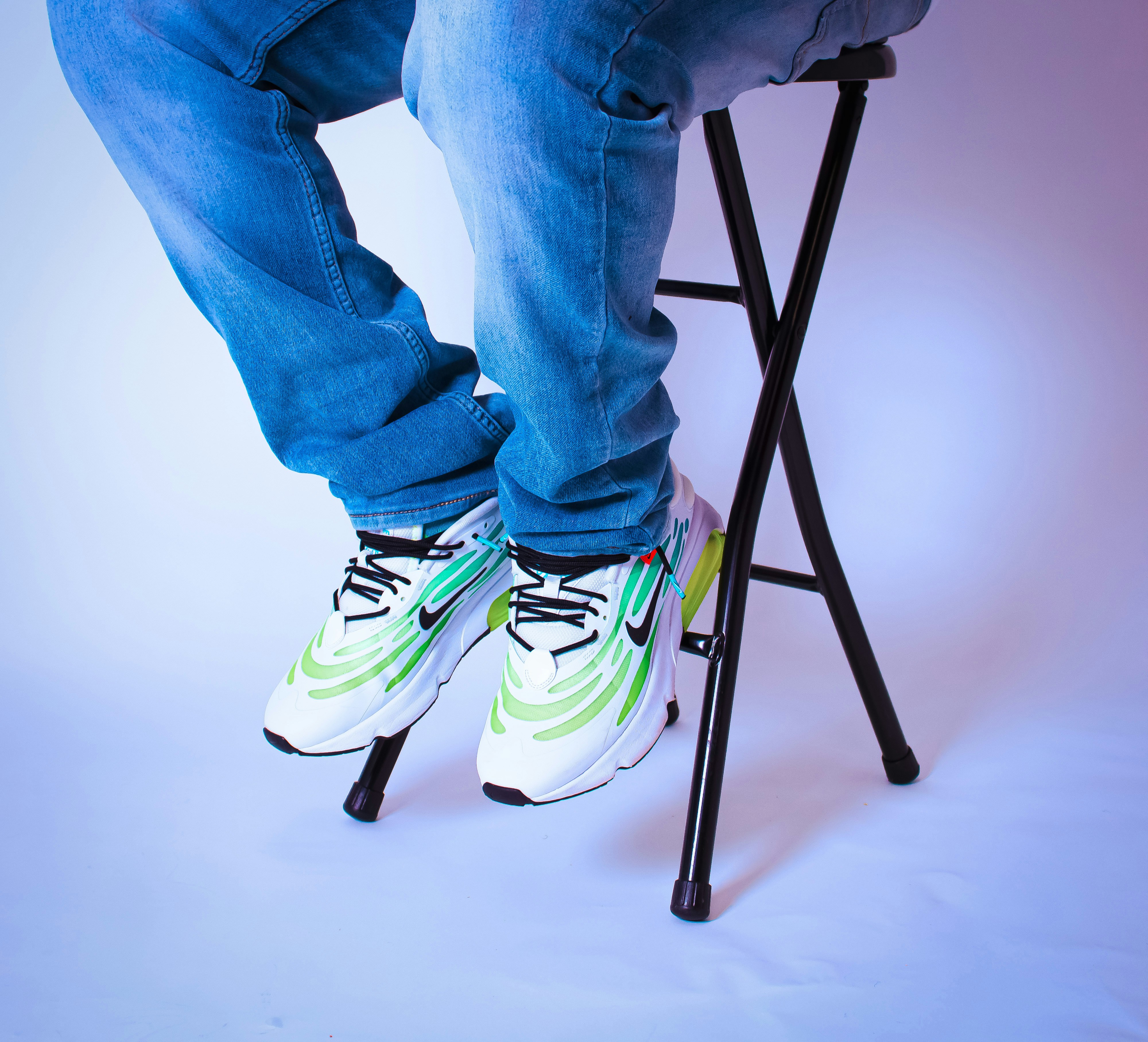 a man sitting on a stool with his legs crossed