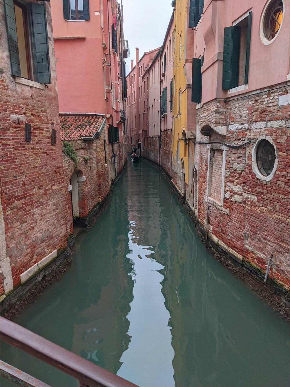 a narrow canal running between two buildings in venice