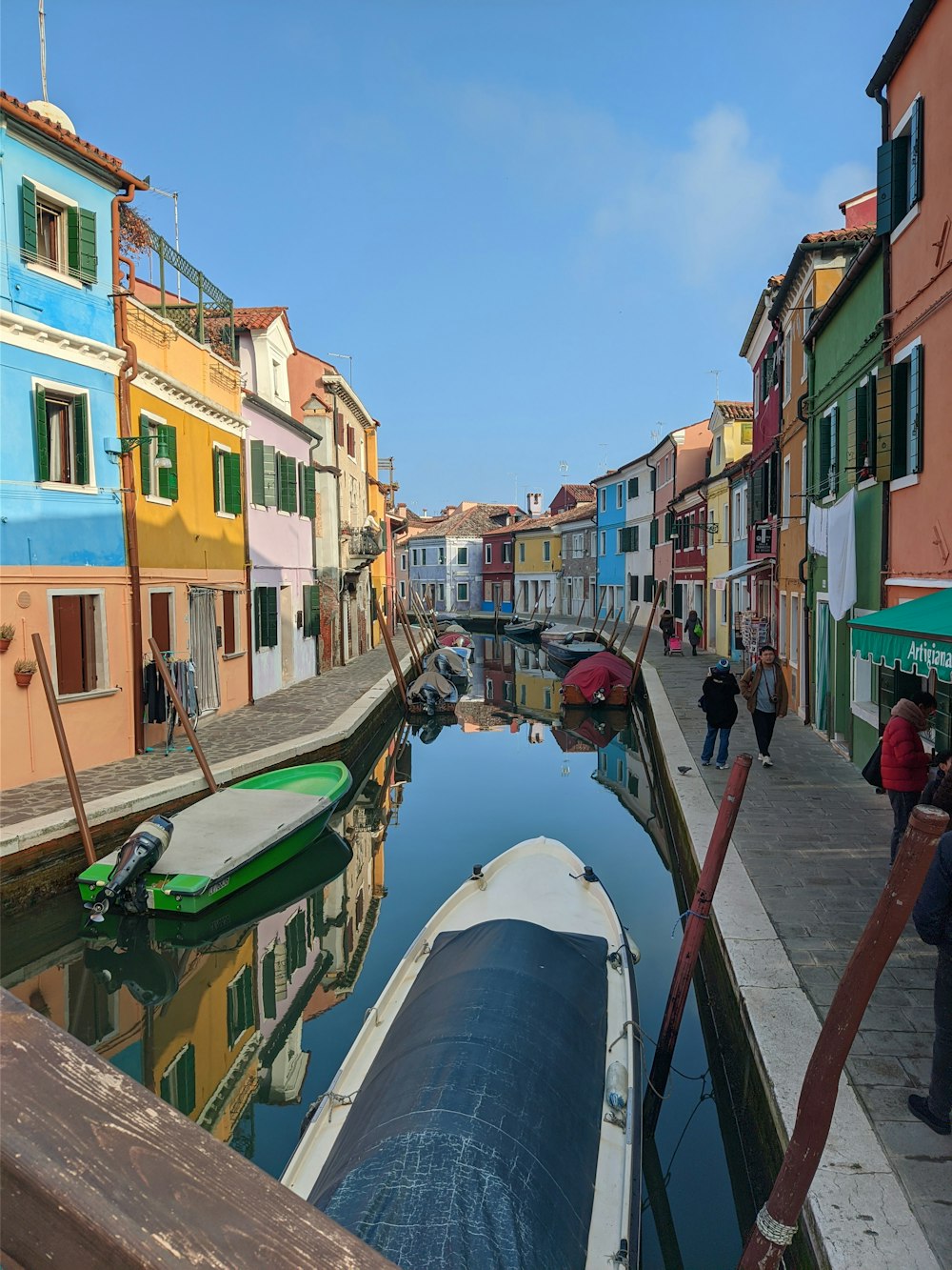a narrow canal with a row of colorful buildings in the background