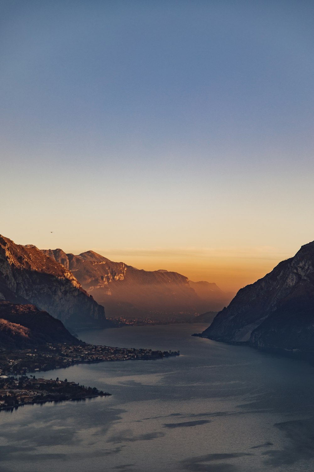 a body of water surrounded by mountains under a blue sky