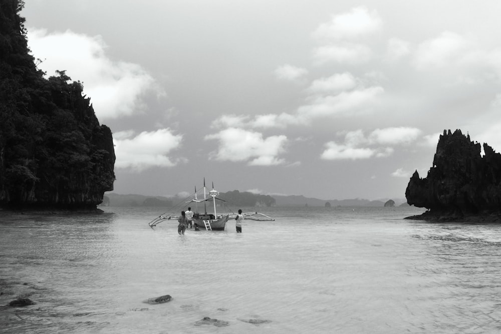 a boat is in the water near some rocks