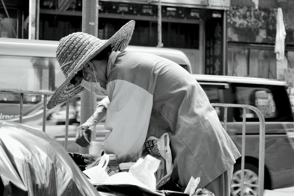 a woman in a hat leaning over a fence