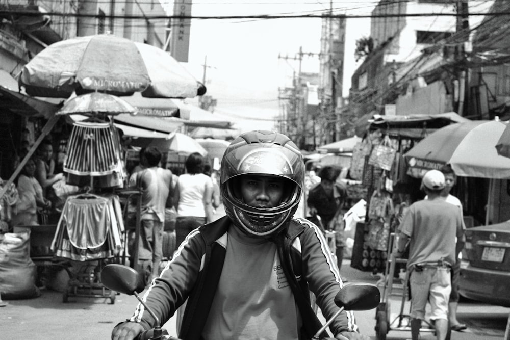 a man riding a motorcycle down a busy street