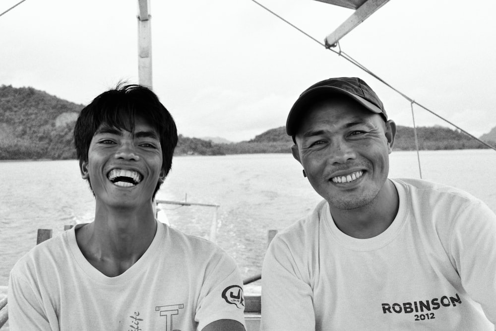 a couple of men sitting next to each other on a boat