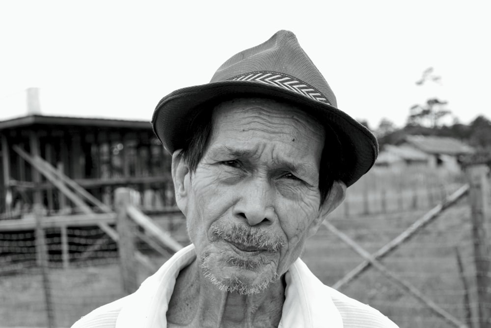 a black and white photo of a man wearing a hat