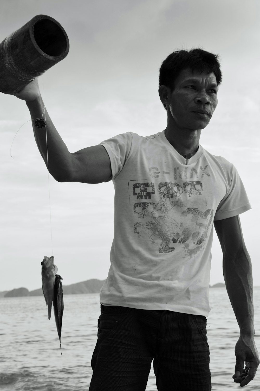 a man holding a fish on the beach