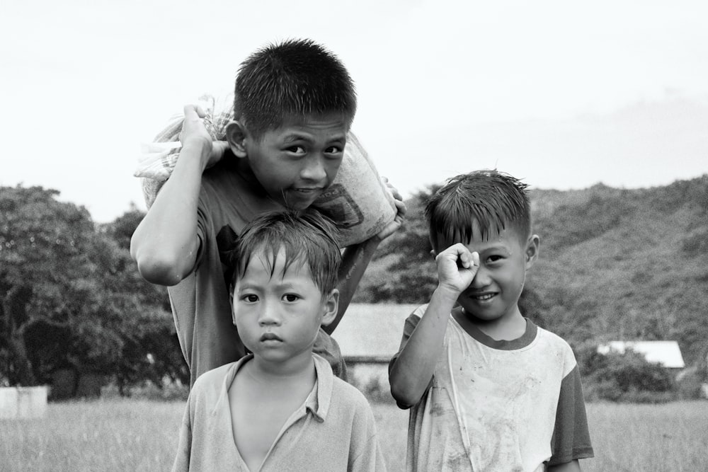 a black and white photo of three children