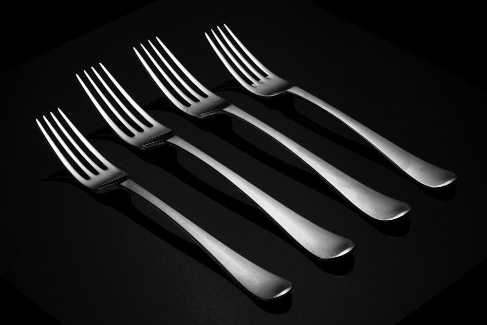 a set of four forks sitting next to each other