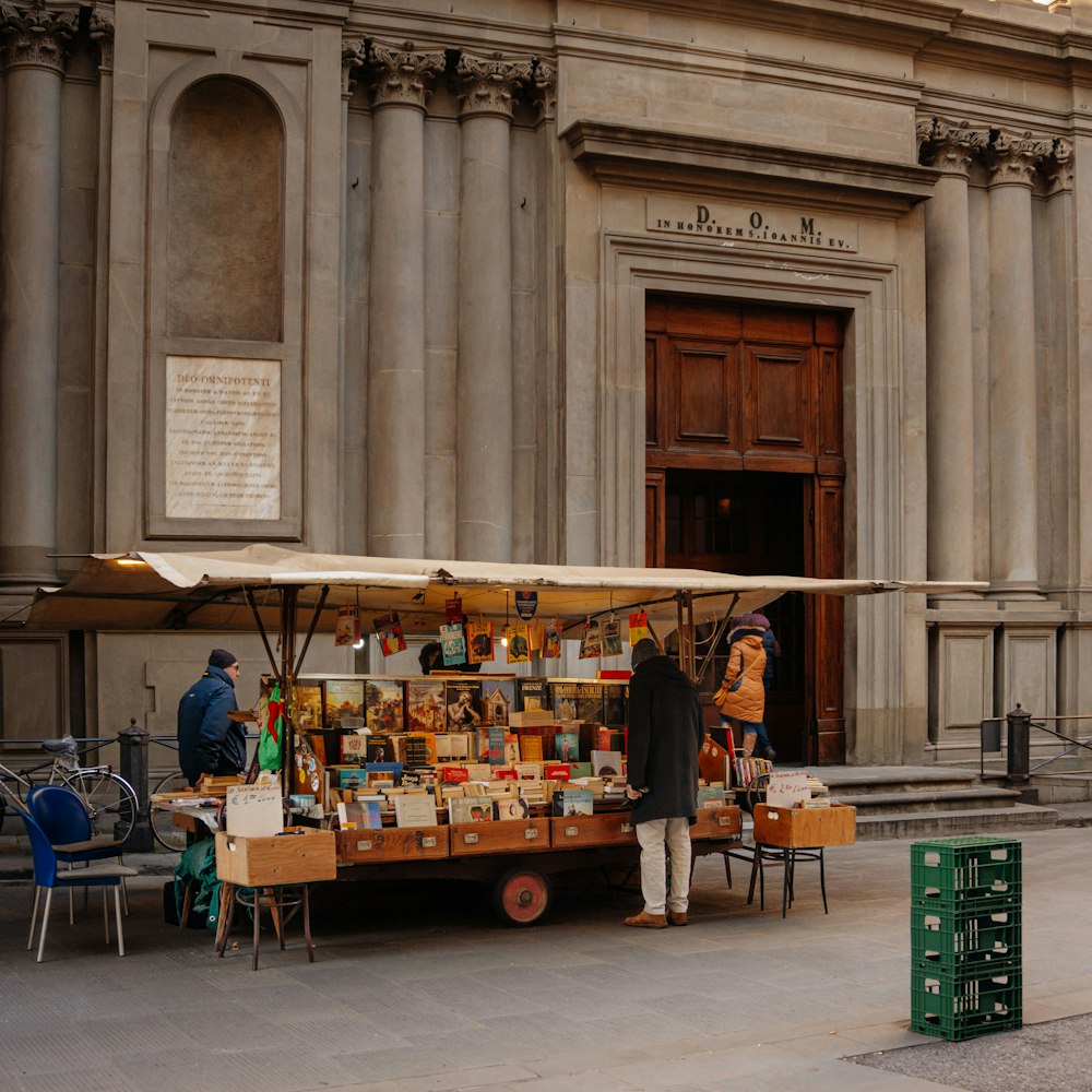 a man is standing in front of a cart selling items