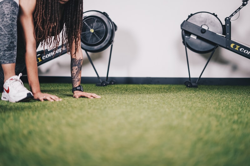 Person using an indoor rowing machine in a gym