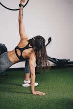a woman in a black sports bra top doing a handstand with a hoop