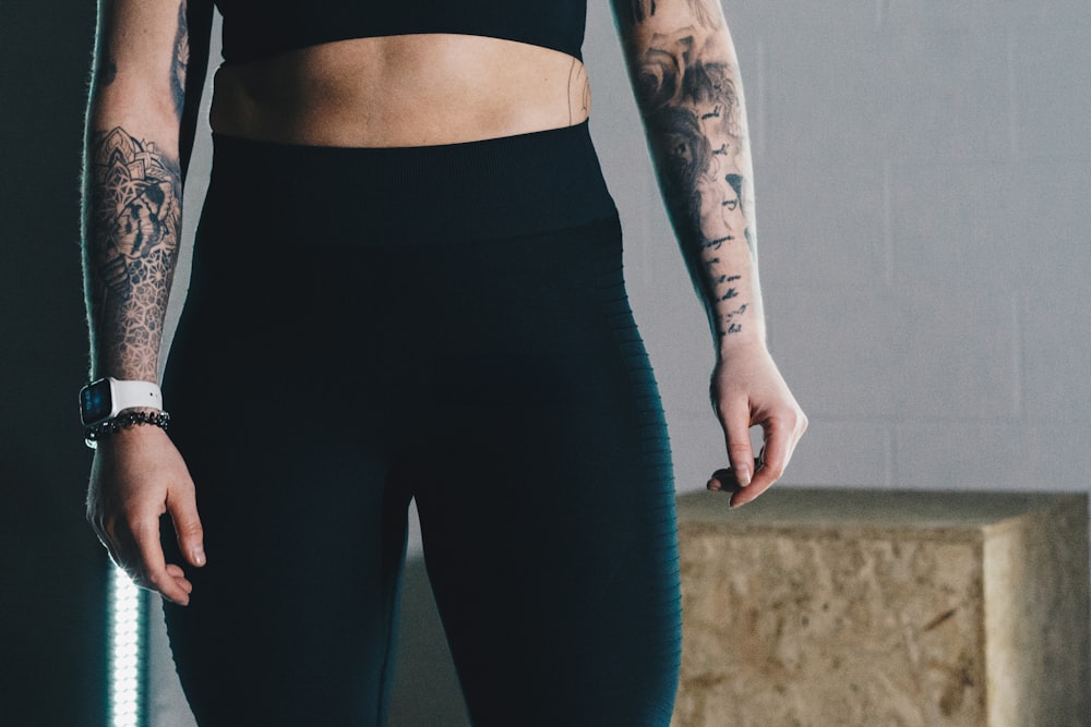 una mujer con un sujetador deportivo negro y leggings