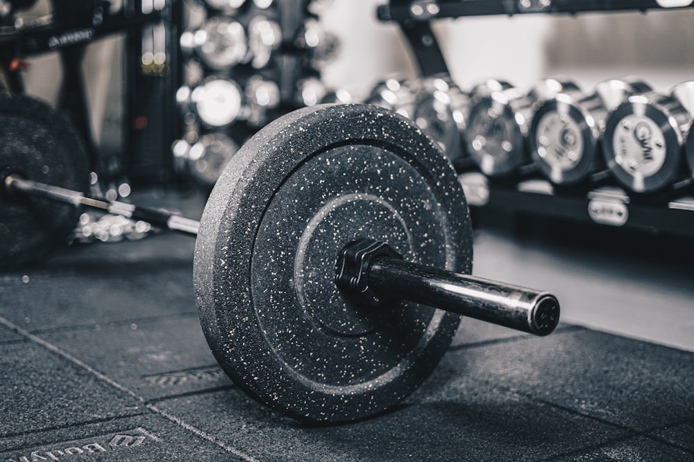 a black and white photo of a barbell in a gym