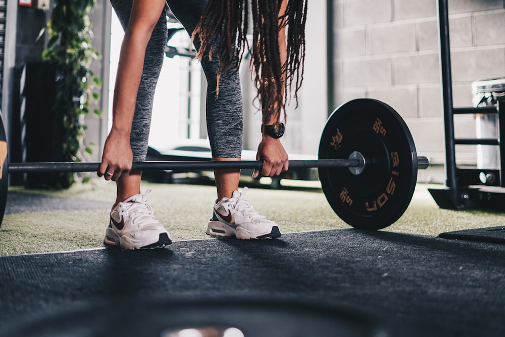 a woman lifting a barbell in a gym