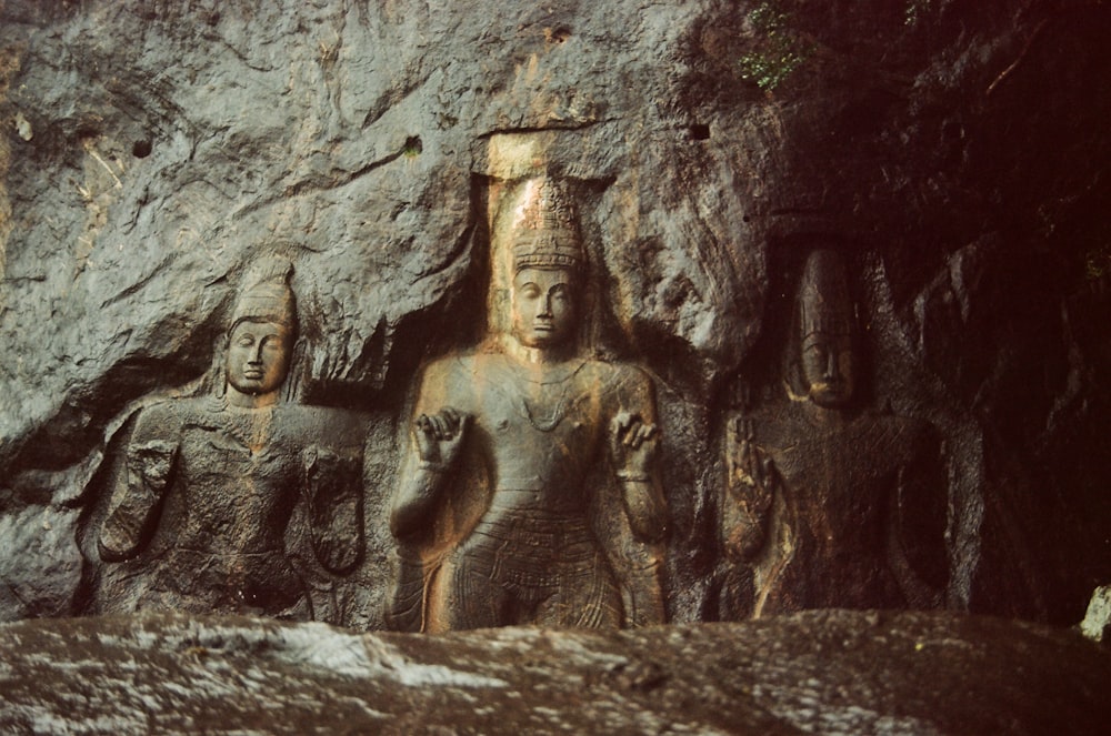 a group of carved figures in a cave