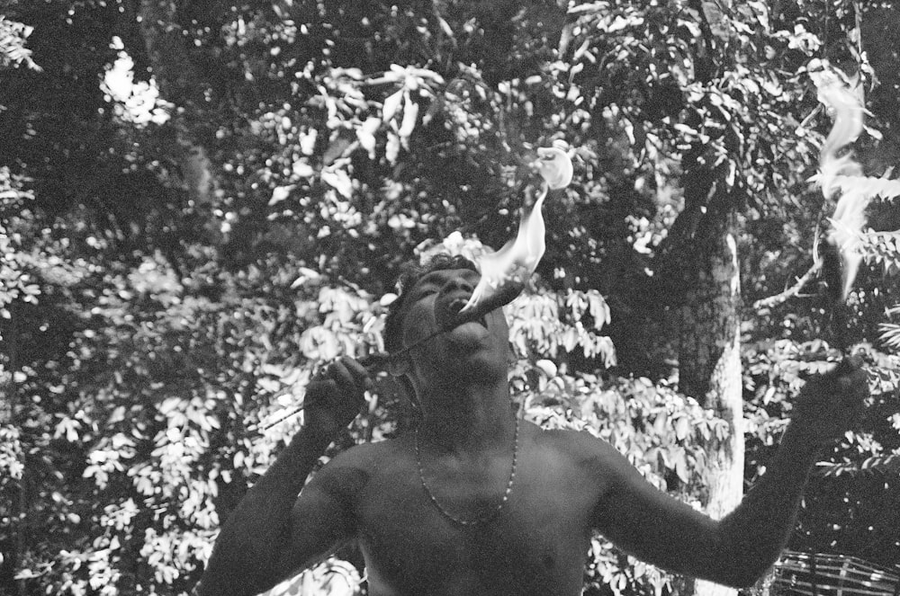 a man standing in front of a forest holding a bird