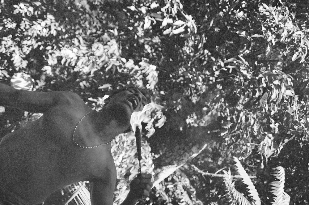 a man standing in front of a tree with a frisbee in his hand