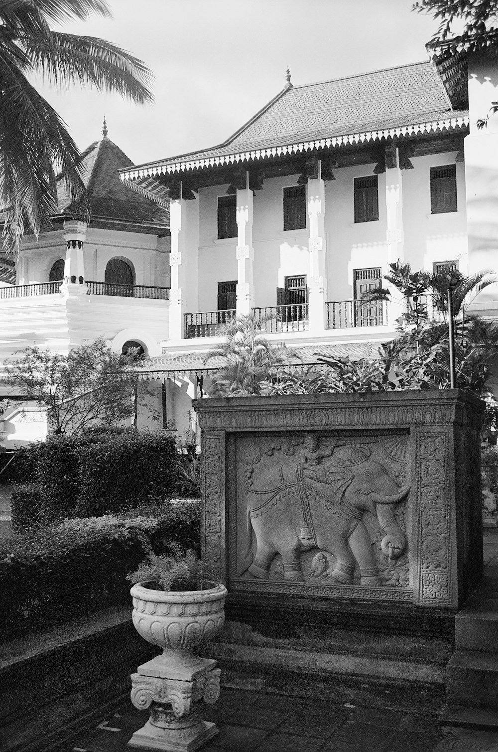 a black and white photo of a building with a statue in front of it