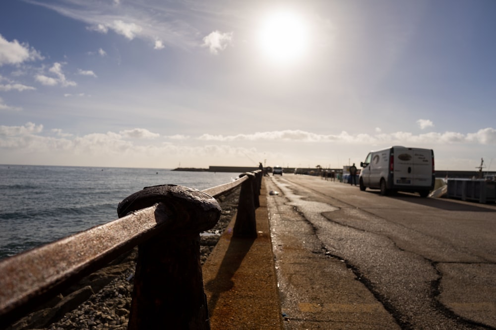 the sun is shining over the water and the road