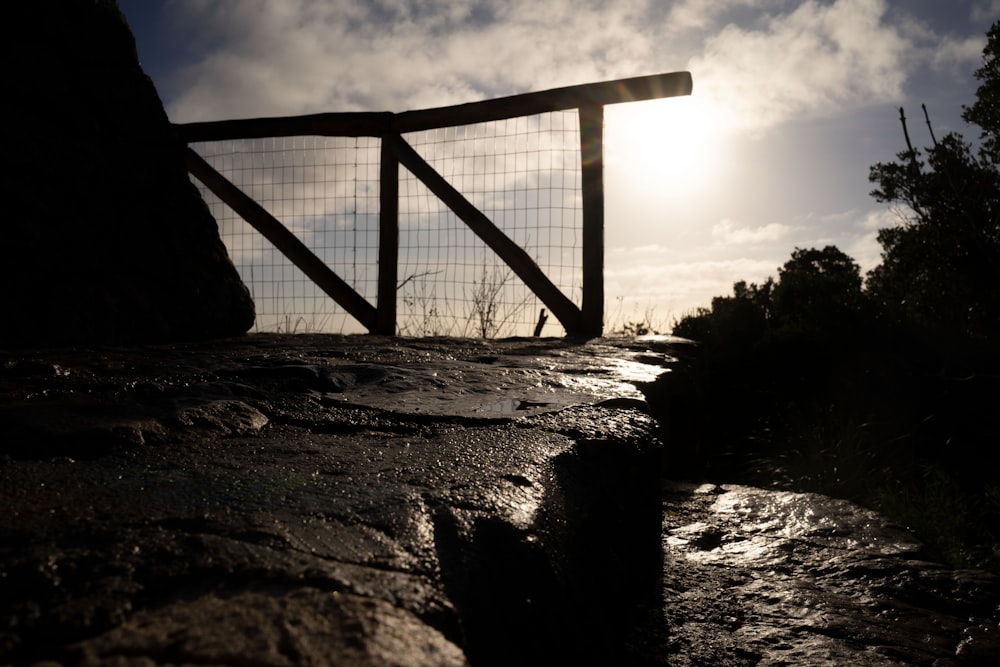 the sun shines through the clouds behind a gate