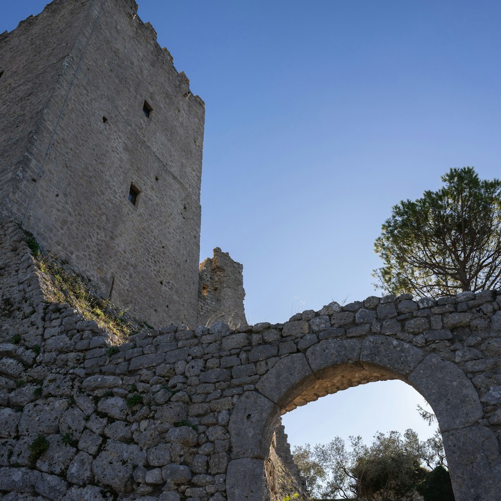 a stone wall with an arch in the middle of it