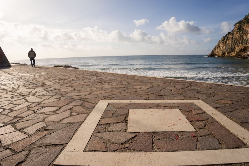 un uomo in piedi su una spiaggia vicino all'oceano