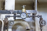 a close up of a toilet with a pressure gauge