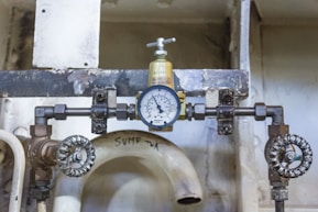 a close up of a toilet with a pressure gauge