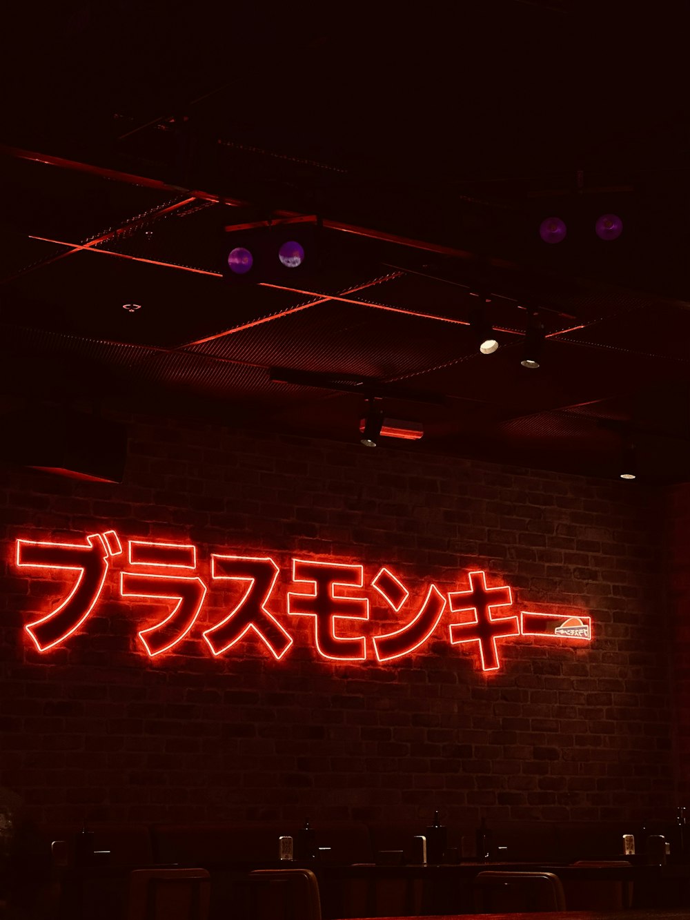 a brick wall with a neon sign on it
