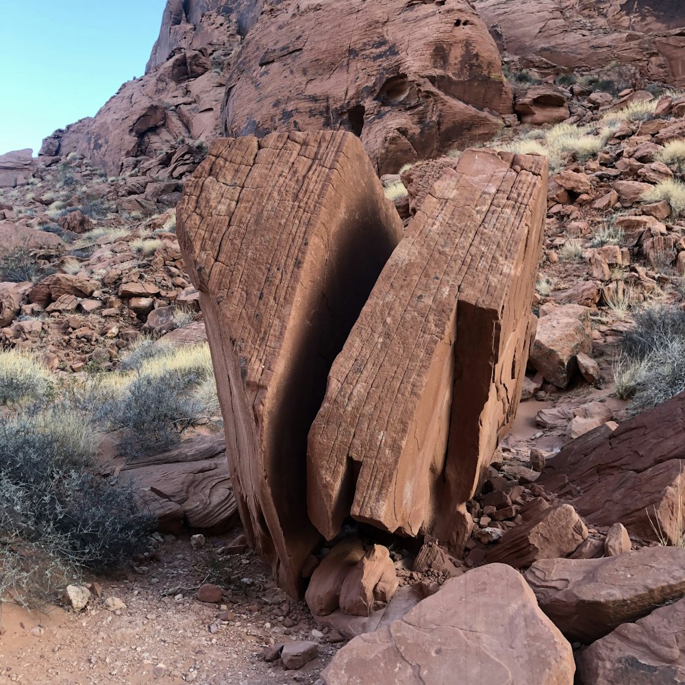 two large rocks sitting on top of a rocky hillside